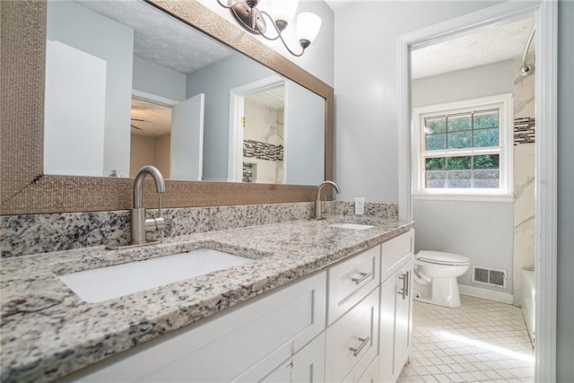 1663 Pounds Rd SW, Stone Mountain, GA 30087 - full bathroom with double vanity, toilet, a textured ceiling, a chandelier, and tile patterned floors