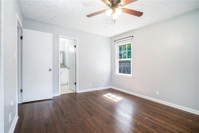 1663 Pounds Rd SW, Stone Mountain, GA 30087 - unfurnished bedroom featuring wood finished floors, a textured ceiling, baseboards, ensuite bath, and ceiling fan