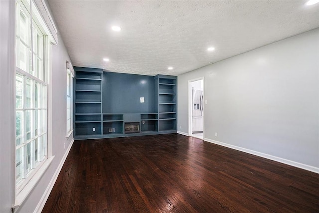 1663 Pounds Rd SW, Stone Mountain, GA 30087 - unfurnished living room with wood finished floors, a textured ceiling, baseboards, recessed lighting, and built in features