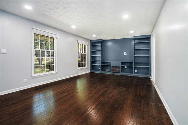 1663 Pounds Rd SW, Stone Mountain, GA 30087 - unfurnished living room featuring hardwood / wood-style floors, a textured ceiling, baseboards, built in features, and recessed lighting