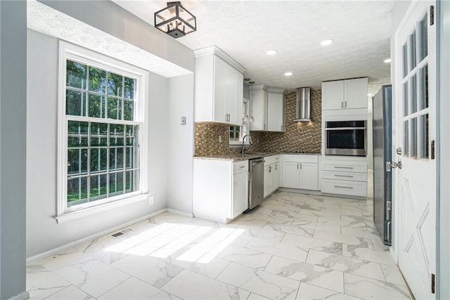 1663 Pounds Rd SW, Stone Mountain, GA 30087 - kitchen featuring stainless steel appliances, wall chimney exhaust hood, light marble finish flooring, baseboards, and recessed lighting
