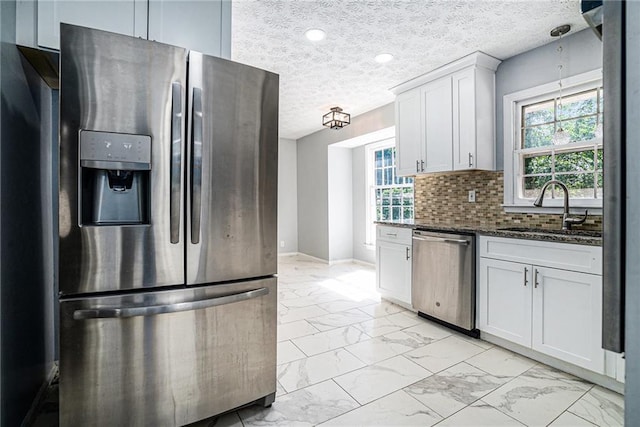 1663 Pounds Rd SW, Stone Mountain, GA 30087 - kitchen with stainless steel appliances, light marble finish floors, a sink, dark stone countertops, and a textured ceiling