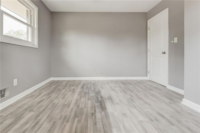 spare room featuring a healthy amount of sunlight and light hardwood / wood-style flooring