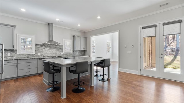 25 Mountain Crest Dr, Oxford, GA 30054 - kitchen with a kitchen breakfast bar, wall chimney range hood, gray cabinets, french doors, and decorative backsplash