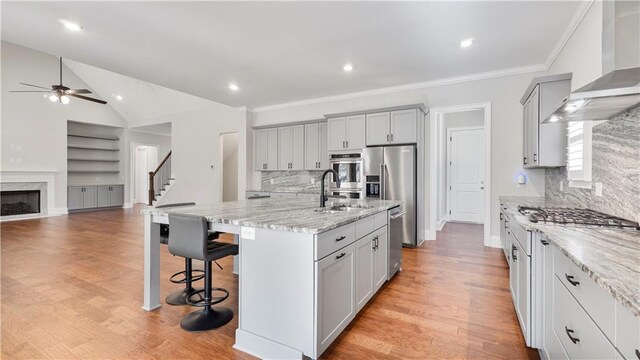 25 Mountain Crest Dr, Oxford, GA 30054 - kitchen featuring wall chimney exhaust hood, a breakfast bar area, appliances with stainless steel finishes, a sink, and ceiling fan
