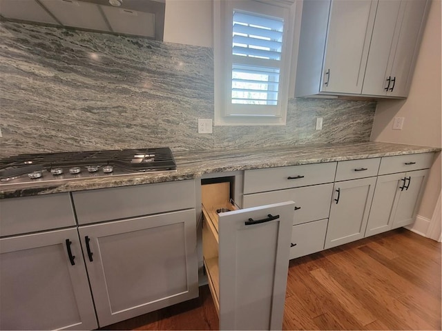 25 Mountain Crest Dr, Oxford, GA 30054 - kitchen featuring light stone counters, backsplash, under cabinet range hood, stainless steel gas cooktop, and wood finished floors
