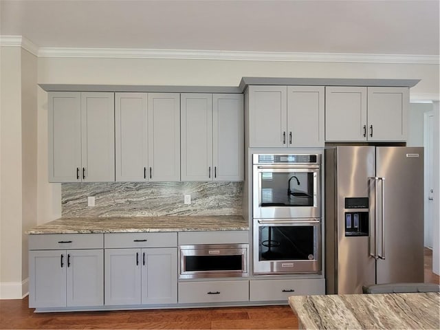 25 Mountain Crest Dr, Oxford, GA 30054 - kitchen with ornamental molding, light stone counters, backsplash, gray cabinetry, and appliances with stainless steel finishes