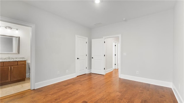 25 Mountain Crest Dr, Oxford, GA 30054 - unfurnished bedroom with light wood-type flooring, a sink, baseboards, and connected bathroom