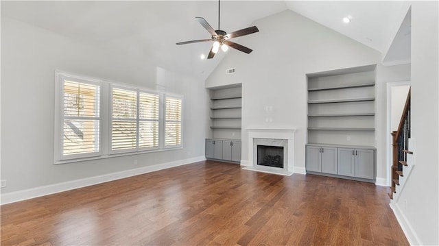 25 Mountain Crest Dr, Oxford, GA 30054 - unfurnished living room featuring built in shelves, baseboards, dark wood-style flooring, a ceiling fan, and stairs