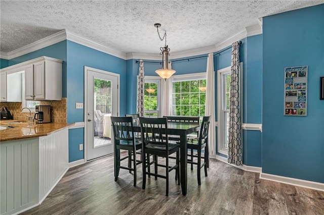 340 Chandler Ct, Sugar Hill, GA 30518 - dining space with dark wood-type flooring, crown molding, a textured ceiling, and baseboards