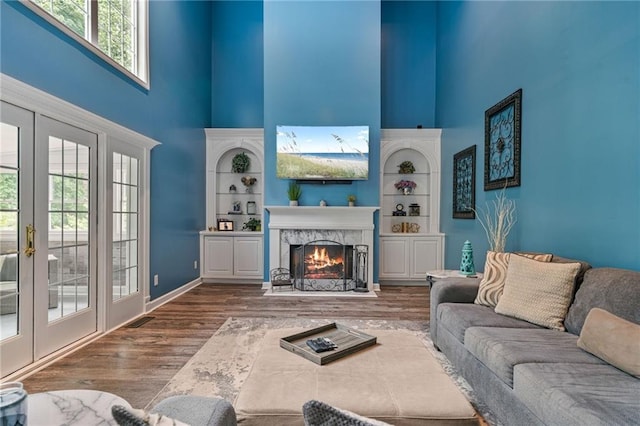 340 Chandler Ct, Sugar Hill, GA 30518 - living area featuring a high ceiling, french doors, wood finished floors, a fireplace, and baseboards