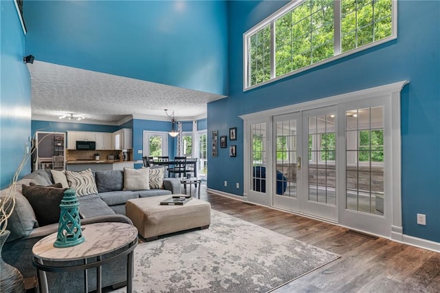 340 Chandler Ct, Sugar Hill, GA 30518 - living room with baseboards, wood finished floors, ornamental molding, a high ceiling, and french doors
