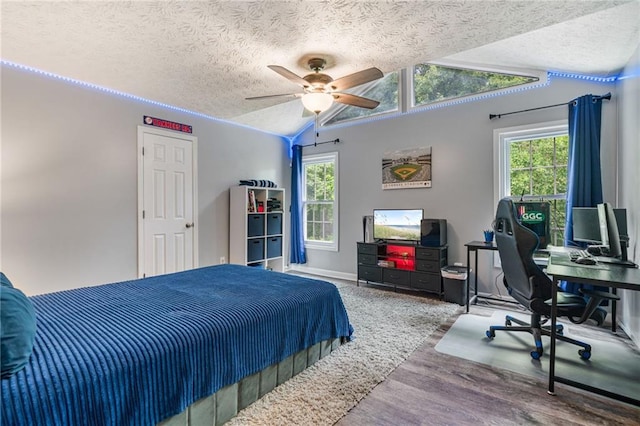 340 Chandler Ct, Sugar Hill, GA 30518 - bedroom with a textured ceiling, vaulted ceiling, an office area, wood finished floors, and a ceiling fan