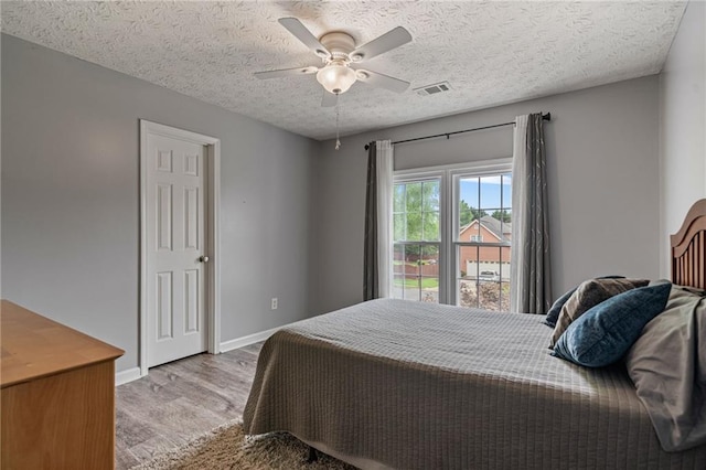 340 Chandler Ct, Sugar Hill, GA 30518 - bedroom featuring wood finished floors, baseboards, a textured ceiling, and ceiling fan
