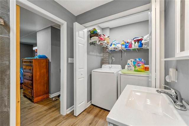 laundry room with sink, light hardwood / wood-style floors, and washing machine and dryer