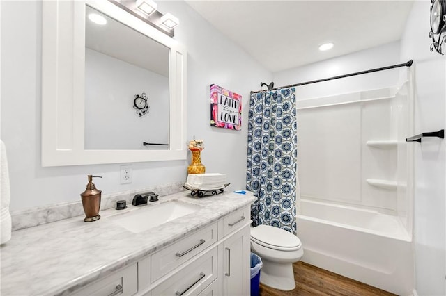 full bathroom featuring wood-type flooring, toilet, vanity, and shower / tub combo