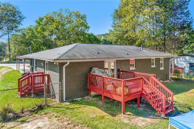 rear view of house featuring a lawn and a wooden deck