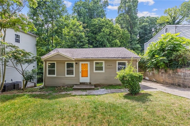 view of front of home featuring a shingled roof and a front yard