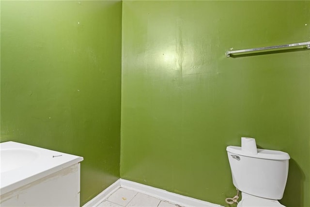 bathroom featuring tile patterned flooring, vanity, toilet, and baseboards