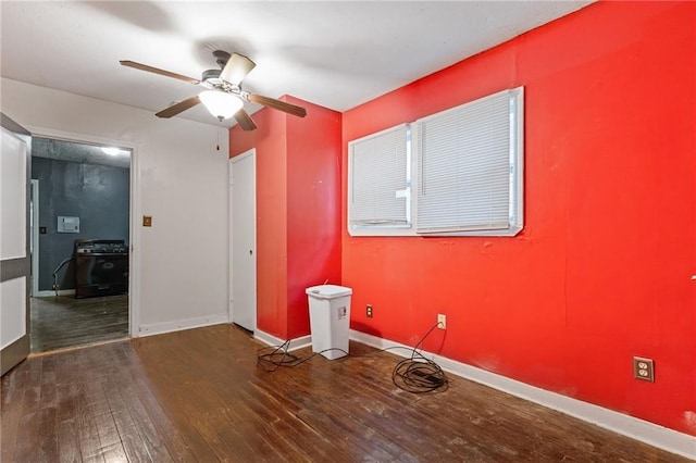 unfurnished room featuring a ceiling fan, hardwood / wood-style flooring, and baseboards