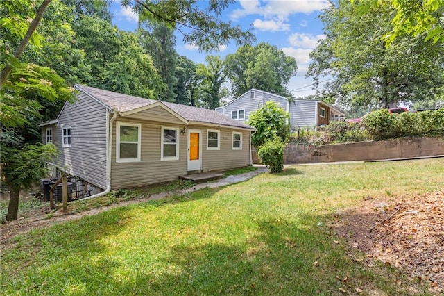 view of front of home with a front yard and fence