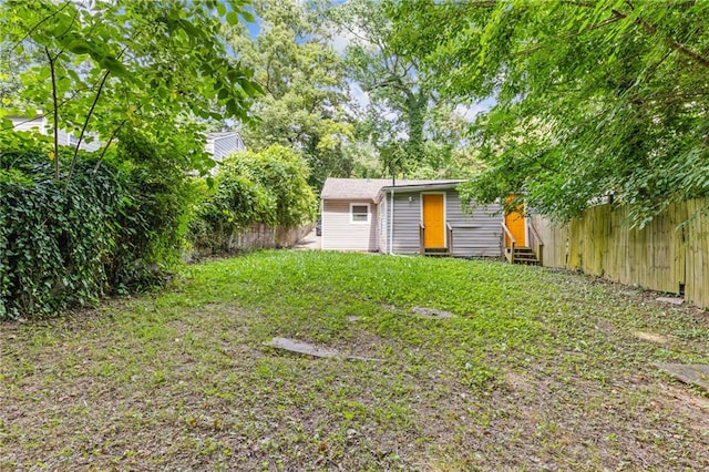 view of yard with entry steps and a fenced backyard