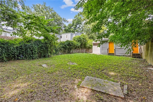 view of yard featuring entry steps and fence