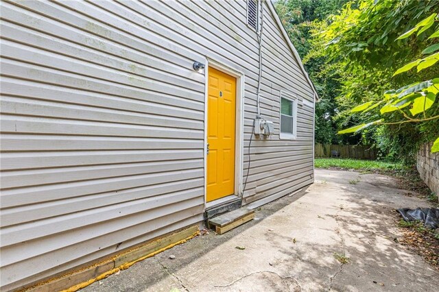 property entrance with fence and a patio