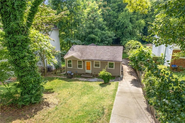 view of front of home with a shingled roof and a front lawn