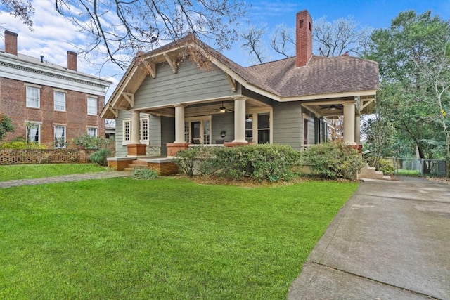 view of front of property featuring ceiling fan, covered porch, and a front yard