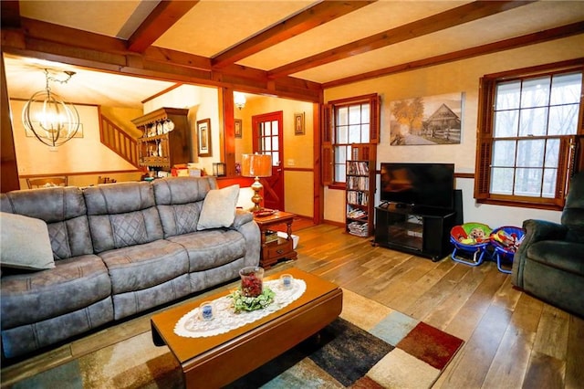 living room featuring beamed ceiling, wood-type flooring, and a chandelier