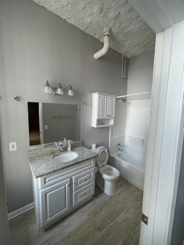 full bathroom featuring vanity, bathing tub / shower combination, and toilet