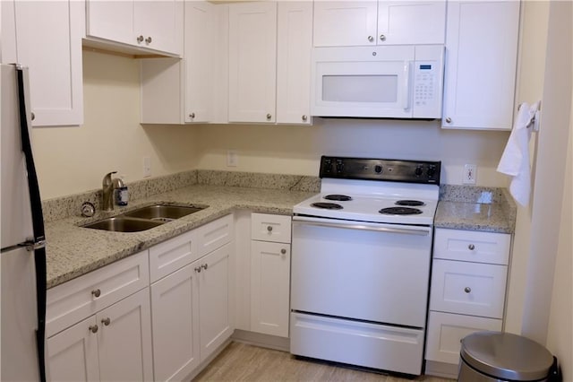 kitchen with white cabinetry, white appliances, and sink