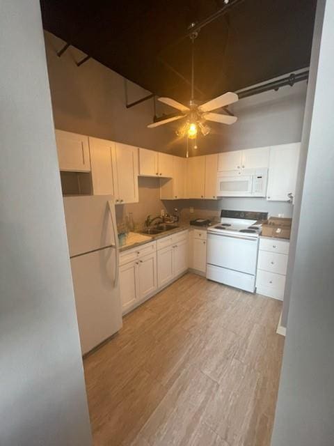 kitchen with ceiling fan, white appliances, white cabinets, and a towering ceiling