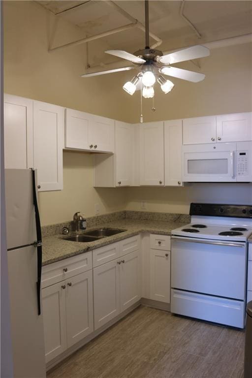 kitchen with sink, white cabinets, white appliances, and light hardwood / wood-style floors