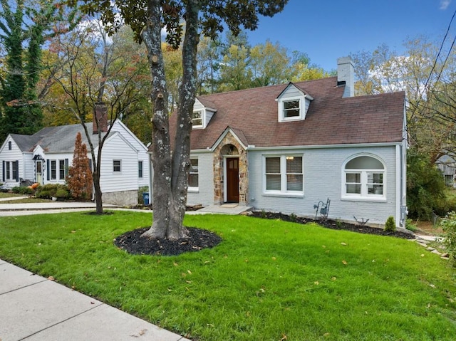 cape cod house featuring a front yard