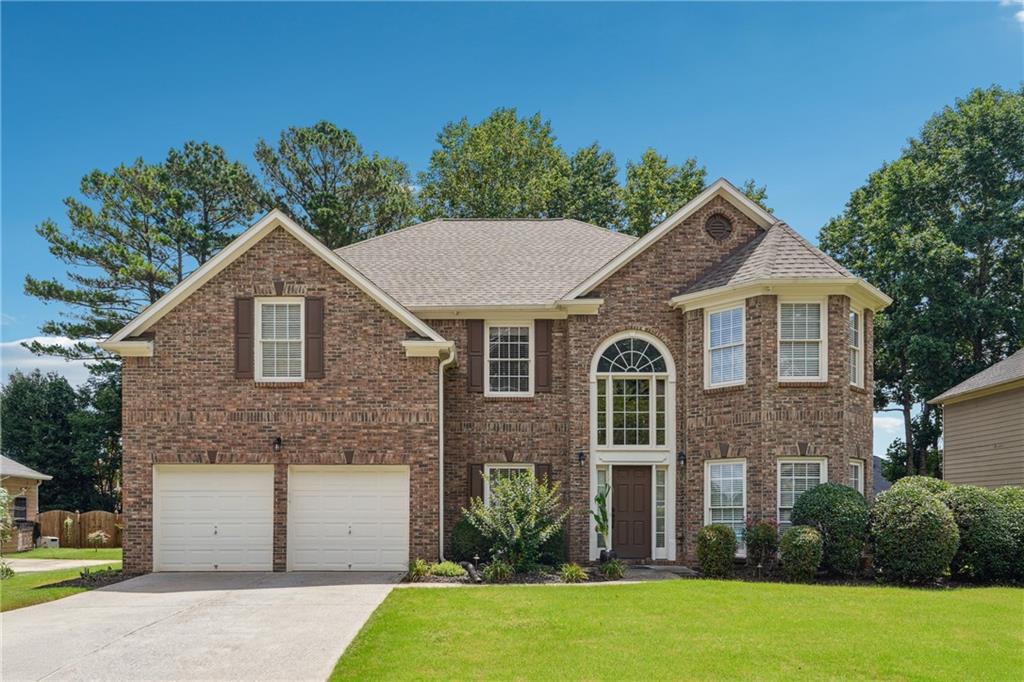 775 Gran Heritage Way, Dacula, GA 30019 - view of front of home featuring concrete driveway, a garage, a front lawn, and brick siding