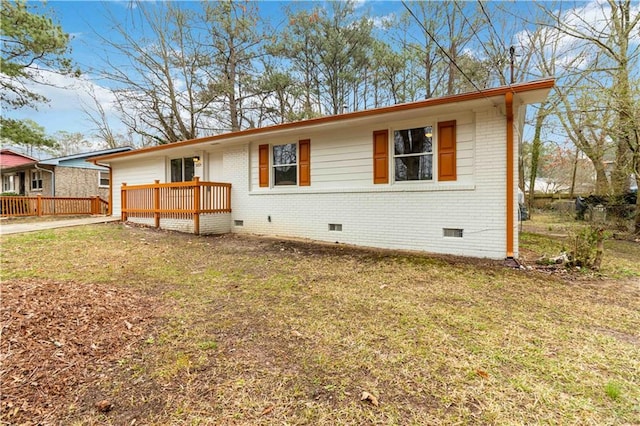 view of front of home with a wooden deck and a front lawn