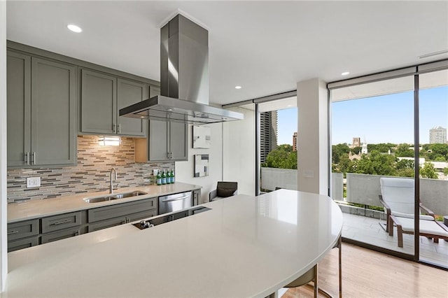 kitchen featuring light hardwood / wood-style floors, sink, a wall of windows, tasteful backsplash, and island exhaust hood