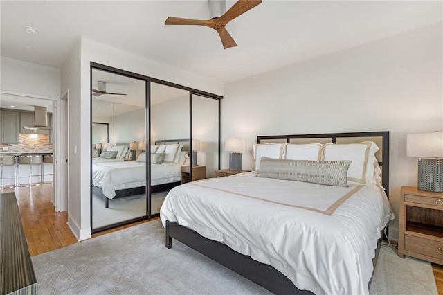 bedroom with a closet, ceiling fan, and light hardwood / wood-style flooring