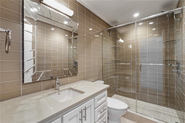 bathroom with toilet, tile walls, vanity, and walk in shower