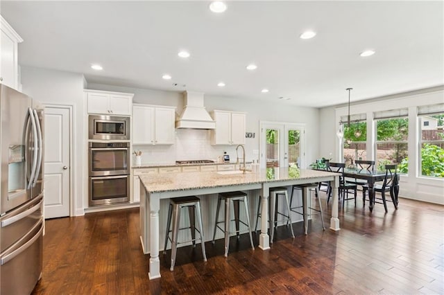 4972 Park Vale Dr, Sugar Hill, GA 30518 - kitchen with stainless steel appliances, premium range hood, a breakfast bar, a center island with sink, and light stone counters