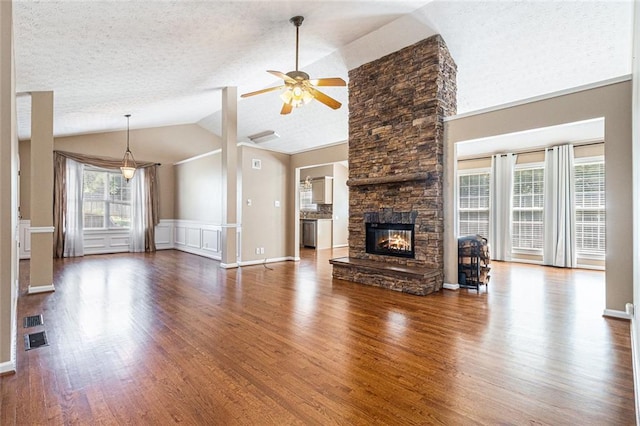 6411 Compass Dr, Flowery Branch, GA 30542 - unfurnished living room with dark wood-style floors, ceiling fan, a stone fireplace, high vaulted ceiling, and a decorative wall