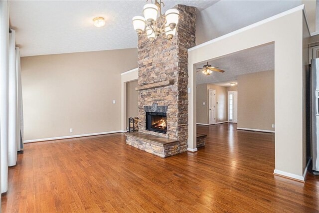6411 Compass Dr, Flowery Branch, GA 30542 - unfurnished living room featuring a stone fireplace, wood finished floors, a chandelier, and a ceiling fan