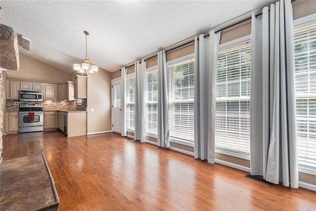 6411 Compass Dr, Flowery Branch, GA 30542 - kitchen featuring appliances with stainless steel finishes, a chandelier, dark wood-type flooring, backsplash, and vaulted ceiling