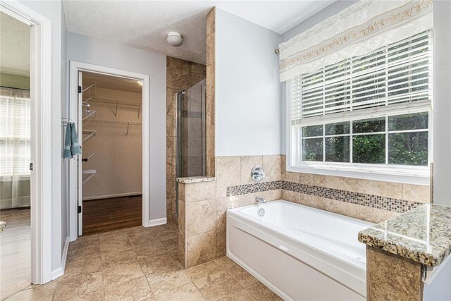 6411 Compass Dr, Flowery Branch, GA 30542 - bathroom with a shower stall, a bath, and a walk in closet
