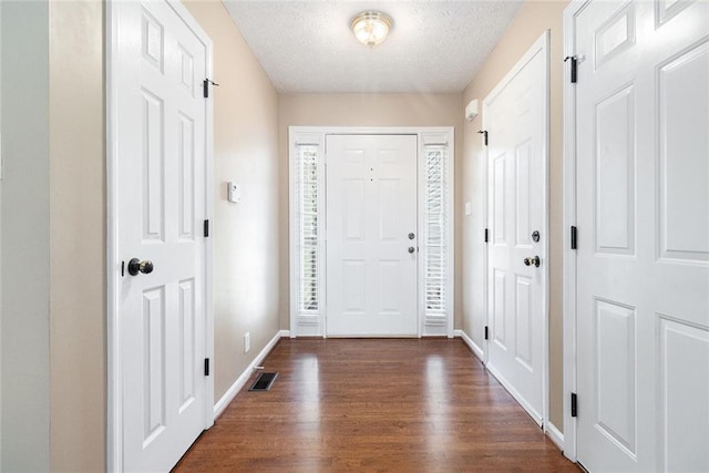 6411 Compass Dr, Flowery Branch, GA 30542 - foyer entrance with dark wood-style floors and a textured ceiling