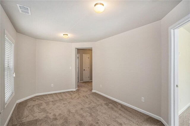 empty room with light carpet, baseboards, and visible vents