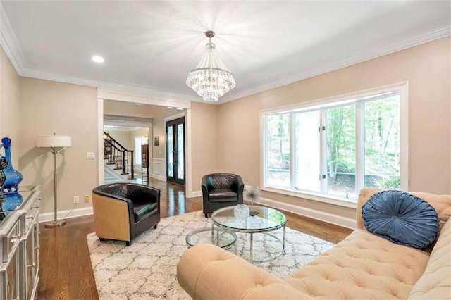 living room featuring a chandelier, wood-type flooring, and ornamental molding