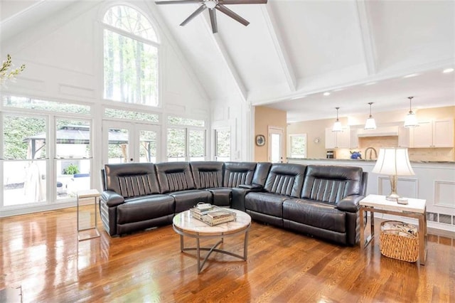 living room with ceiling fan, a healthy amount of sunlight, light hardwood / wood-style flooring, and high vaulted ceiling